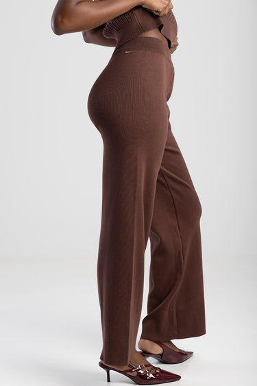 side view of a person wearing brown knit wide‑leg pants with a high waist and burgundy heeled mules