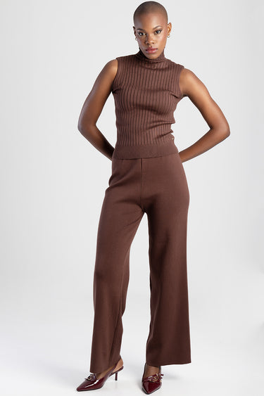 woman wearing a brown ribbed sleeveless turtleneck top with matching wide leg trousers and burgundy pointed heels