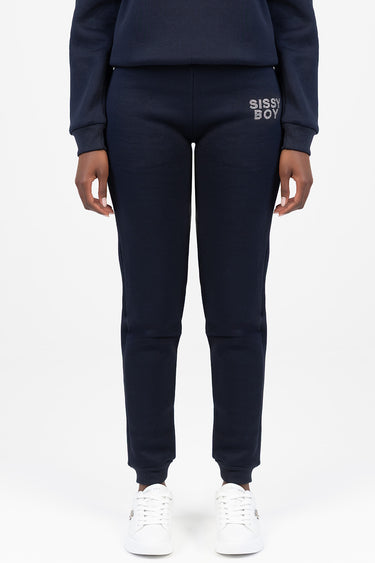 navy blue jogger pants with white embroidered text on the hip, model wearing white sneakers