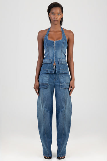 woman wearing blue denim balloon-leg jumpsuit with halter top and cargo pockets