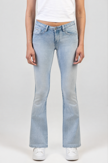 front view of light wash blue bootcut jeans on a person wearing white sneakers