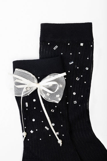 black knit socks with a sheer white bow and scattered rhinestones on the cuff