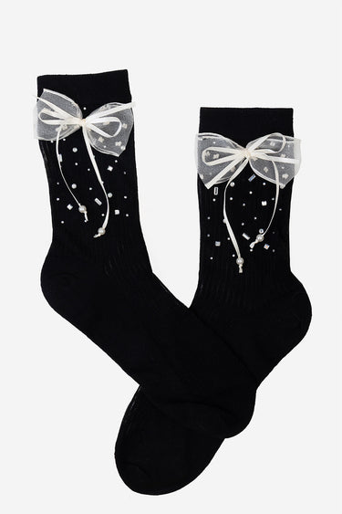 pair of black socks with white sheer bow decorations and scattered crystal beads at the cuffs