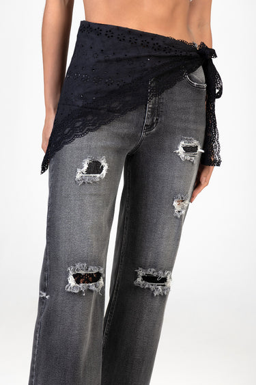 woman wearing black lace wrap tied at the waist over distressed jeans