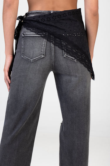 black lace wrap tied at the waist over grey denim jeans, back view