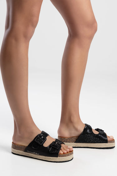 black two strap espadrille sandals with buckles on a model's feet, cork sole and jute edge