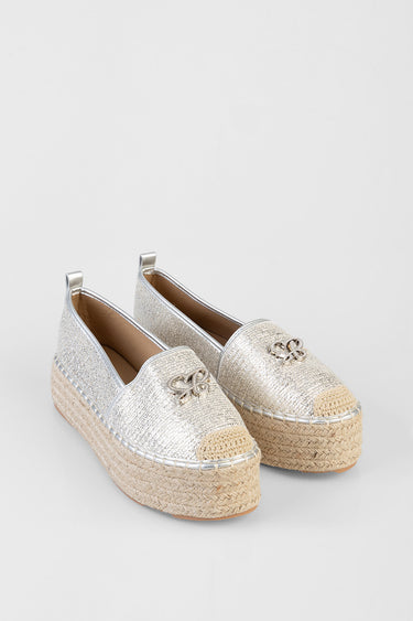 pair of silver glitter espadrilles with platform jute sole, rounded toe, woven toe cap and small metal bow accent