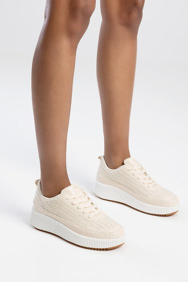 cream knitted sneakers with a thick white platform sole worn by a model