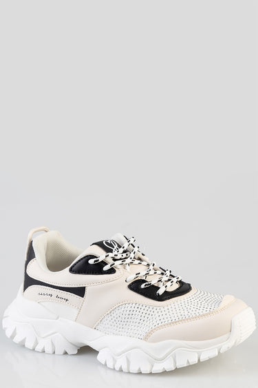 cream and black chunky sneakers with mesh panels and a thick white sole