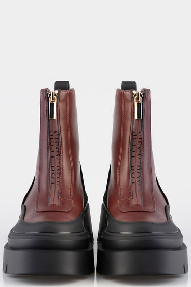 pair of burgundy leather boots with gold zippers and chunky black soles, front view