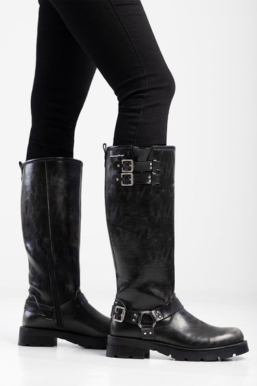 blue jean traders black knee high boot with buckled straps and side zip, worn over black jeans