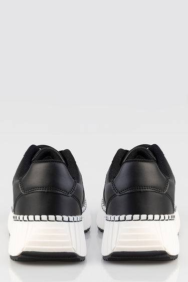 blue jean traders black sneakers with white platform soles, back view