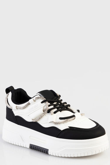 white and black chunky sneaker with silver rope laces and a thick white sole