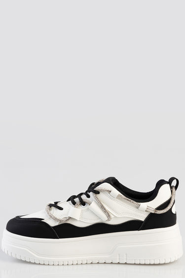 white and black platform sneaker with a chunky sole and rhinestone lace details