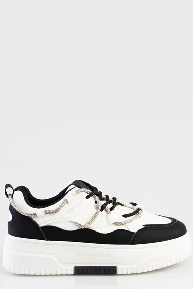 white and black platform sneaker with rhinestone lace loops and a chunky white sole