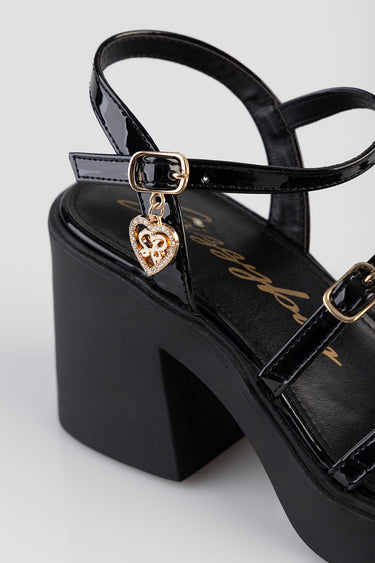 black patent heel sandal with a chunky block heel and ankle strap, gold heart charm pendant