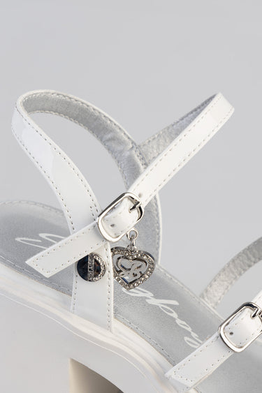 white and light gray heeled sandal with ankle strap, buckle, and silver heart charm