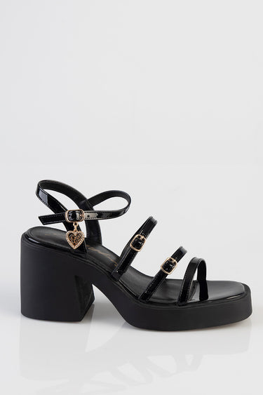 black patent strap sandals with a chunky block heel and a gold heart charm