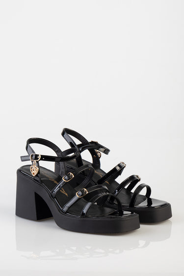 blue jean traders black patent heeled sandals with multiple straps and a gold heart charm