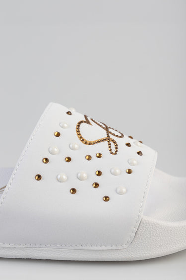 white slide sandal by Blue Jean Traders with gold and white studs and logo detail