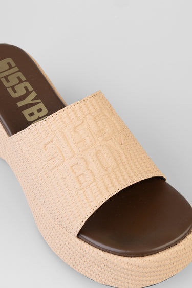 beige platform sandal with a wide textured strap and a dark brown toe cap, logo detail on the strap