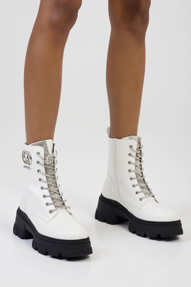 white ankle boots with chunky black soles, silver glitter laces, metal eyelets, side zipper, and a small logo patch