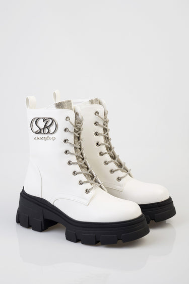 white leather combat boots with thick black soles, silver glitter tongue, metal eyelets, and a logo patch on the side