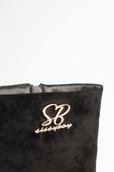 black suede boot with a gold initials logo on the side of the shaft