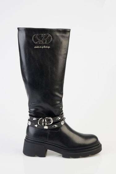 black knee high leather boot with a chunky sole, silver studded strap around the ankle, and a metallic logo on the shaft