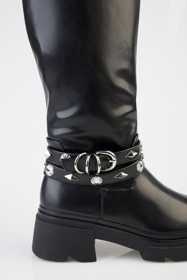 black knee high boot with a chunky sole and two studded straps featuring silver rings around the ankle