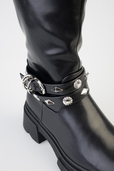 black knee high boot with a chunky sole and double strap around the ankle adorned with silver studs