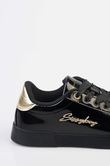 black patent sneaker with gold metallic heel cap, gold embroidered script on the side, black laces and sole