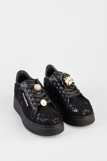 black lace sneakers with thick sole and black satin laces, gold and pearl floral pins on the tongues