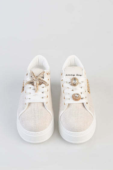 white canvas sneakers with a gold rhinestone star on the left and crystal brooches on the right