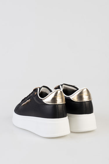 Blue Jean Traders sneakers, black upper with metallic gold heel caps and a chunky white sole.
