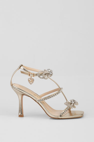 gold strappy high heel sandal with crystal embellishments and a heart charm