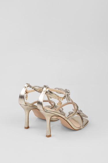 metallic gold strappy sandals with rhinestone embellishments, heart charm accents, ankle strap and slender kitten heels