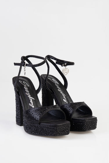 black rhinestone platform heels with ankle straps, open toe, and a small heart charm