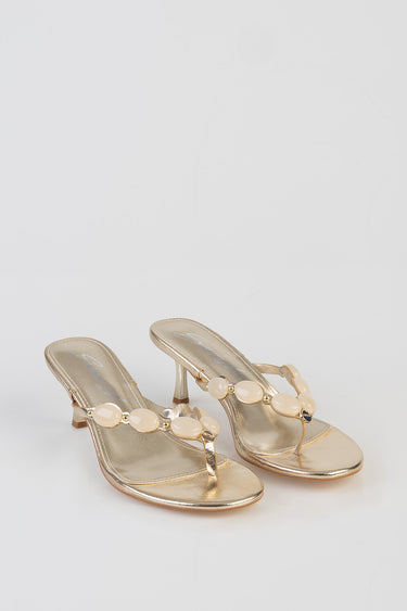 gold metallic sandals with a thin thong and circular beige beads on the strap, low block heel