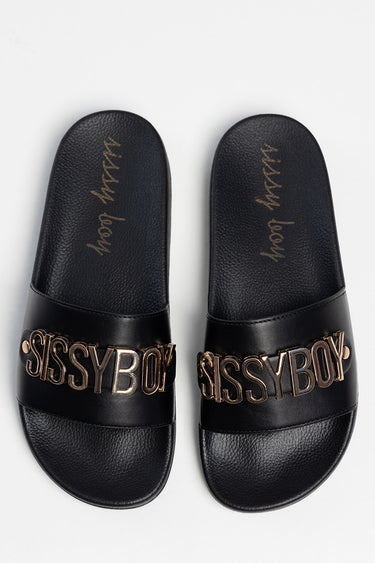 black flat slide sandals with a wide strap and metallic sissyboy lettering across the band, textured footbeds