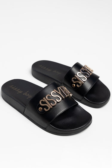 Blue Jean Traders black flat sandals with a wide strap and rose gold metal lettering