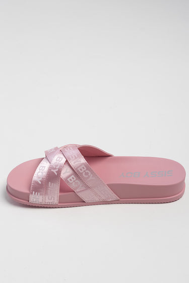pink slide sandal with two crossed straps and a flat sole, pale pink with white lettering on the straps