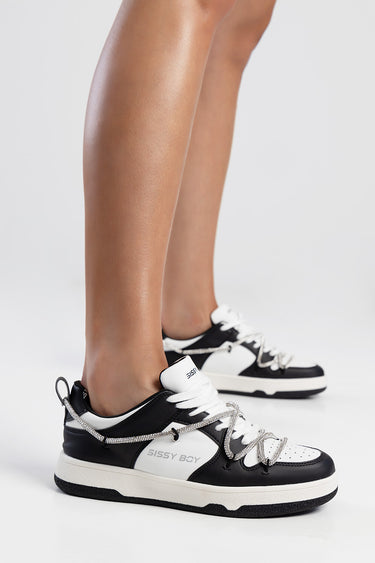 black and white sneakers with silver braided laces and a thick off white sole, side reads Sissy Boy