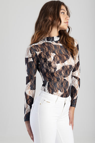 woman wearing a sheer lace long sleeve top with high neckline in black and beige camouflage pattern