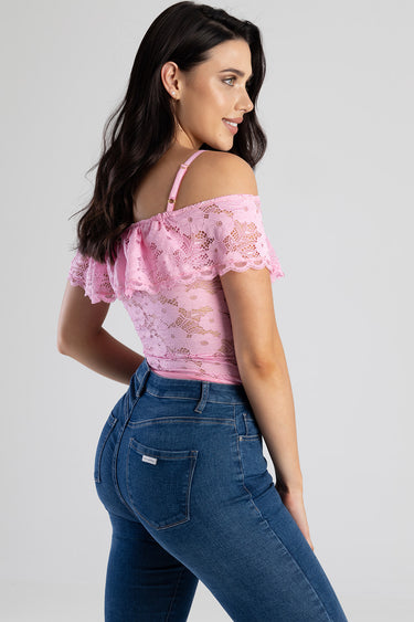 woman wearing pink lace off shoulder top with ruffles and floral pattern, paired with blue high waist jeans