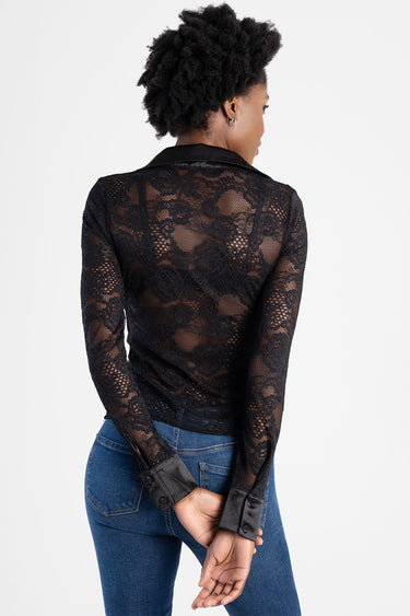 woman wearing black lace long sleeve blouse with satin collar and cuffs, sheer floral pattern, paired with blue jeans