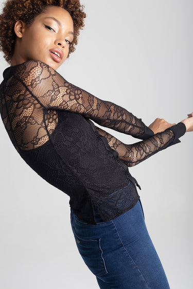 woman in black lace blouse with long sleeves and front buttons, paired with blue denim jeans