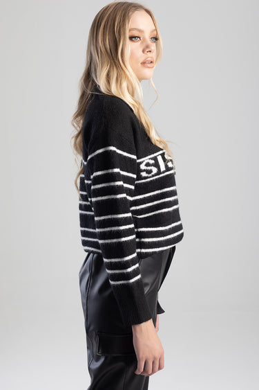 woman wearing a black and white striped knit sweater, side view, by blue jean traders