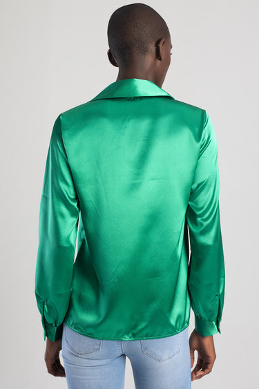 back view of a person wearing a green satin blouse with long sleeves and a collar, paired with light blue jeans