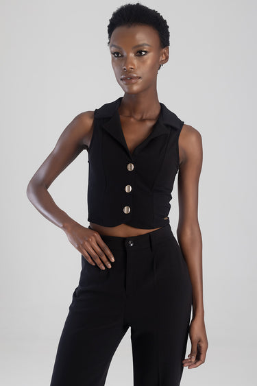 black sleeveless waistcoat with wide lapels and four gold buttons worn with black tailored trousers on a model